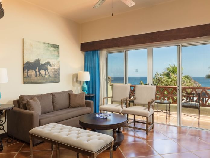 Lounge with sofa chairs and oceanfront balcony featuring sea view in One Bedroom Villa at Hacienda Del Mar Los Cabos.