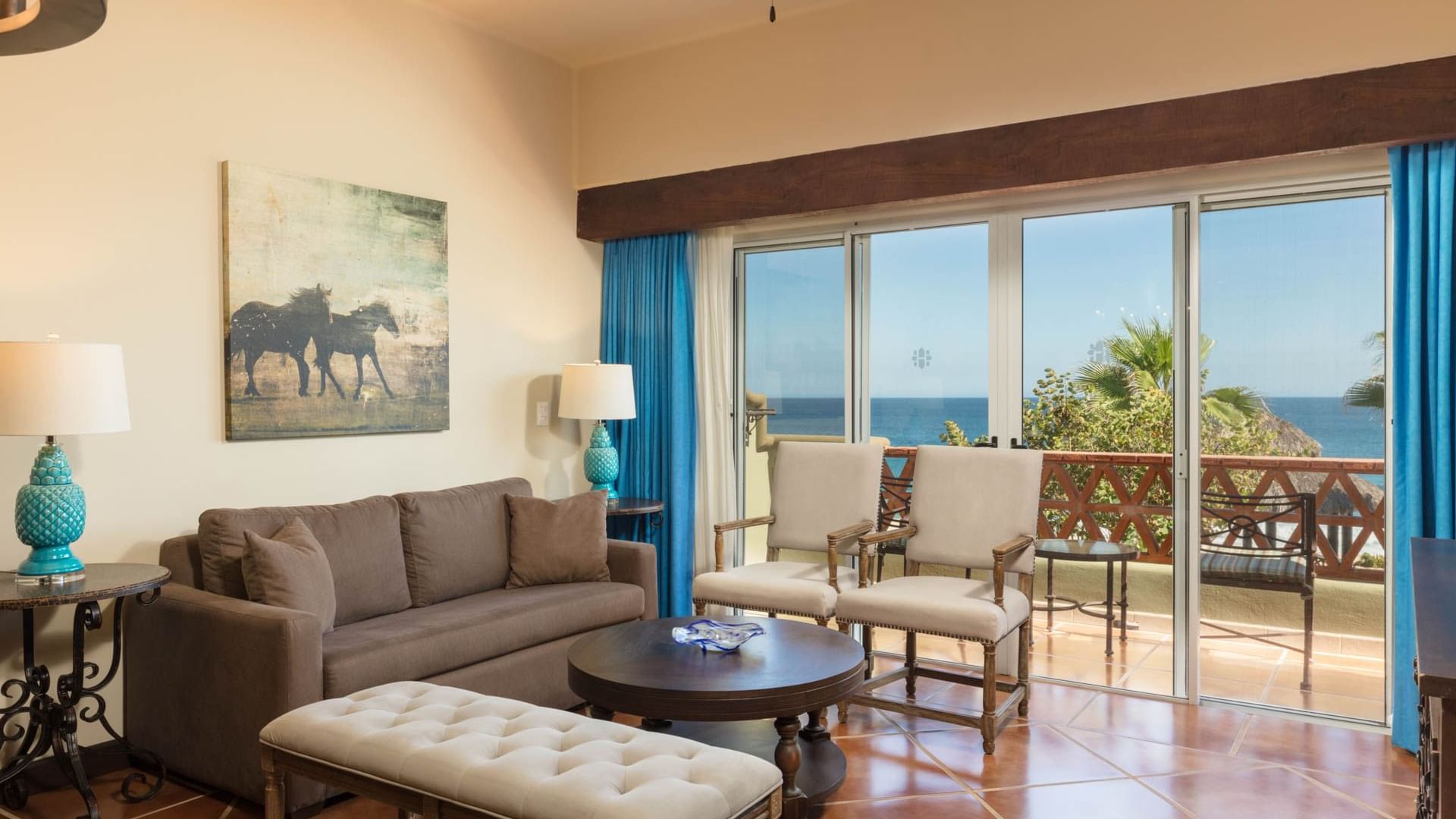 Lounge with sofa chairs and oceanfront balcony featuring sea view in One Bedroom Villa at Hacienda Del Mar Los Cabos.