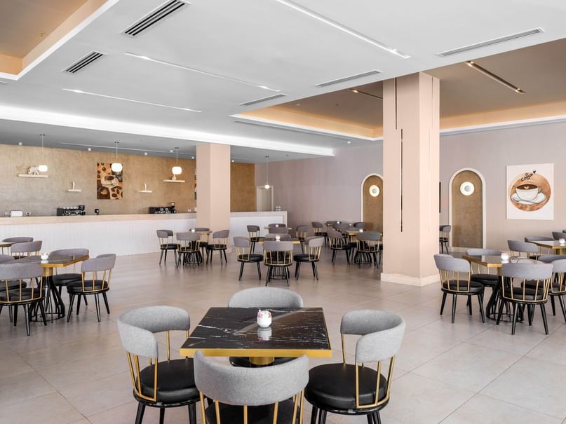 An empty restaurant with tables, chairs, and a counter, showcasing a modern and minimalist design.