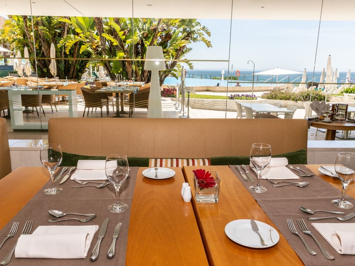 Tables mises au Restaurant Oásis Terrace avec vue sur la piscine et l'océan à l'Hotel Cascais Miragem Health & Spa.