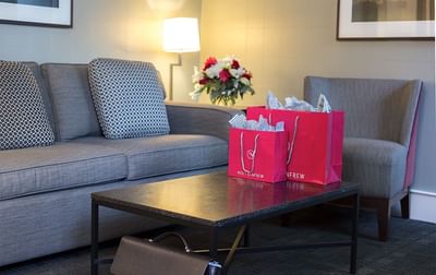 Two Holt Renfrew bags on the coffee table in Executive Suite's lounge area at The St. Regis Hotel Vancouver