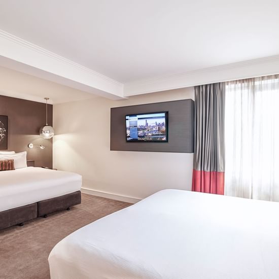 Queen bed and king bed in Deluxe Suite with carpeted floors at Pullman Albert Park