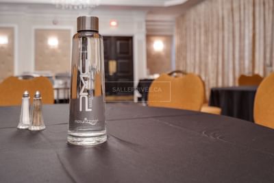 Bottled water and salt and pepper shaker on banquet table.