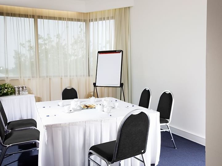 Table set-up with a screen in an M-Room at Pullman Albert Park