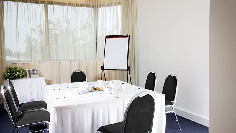 Table set-up with a screen in an M-Room at Pullman Albert Park