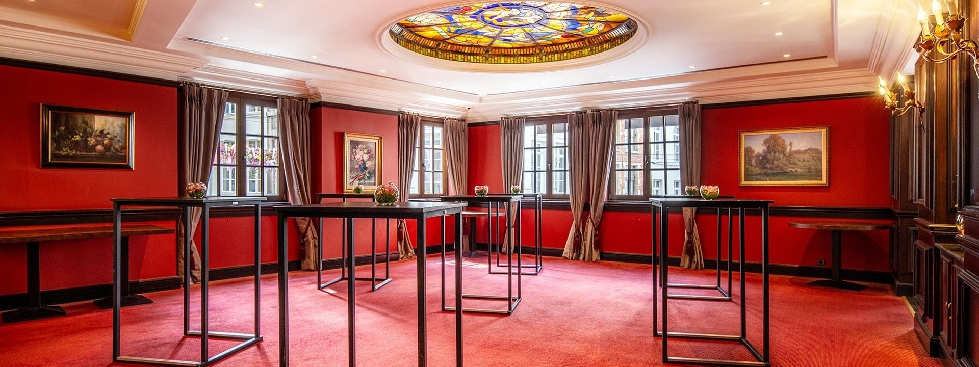 L'élégante salle de réception « Salon Grand-Place », avec tapis rouge et tables en verre, au Warwick Grand-Place Brussels.
