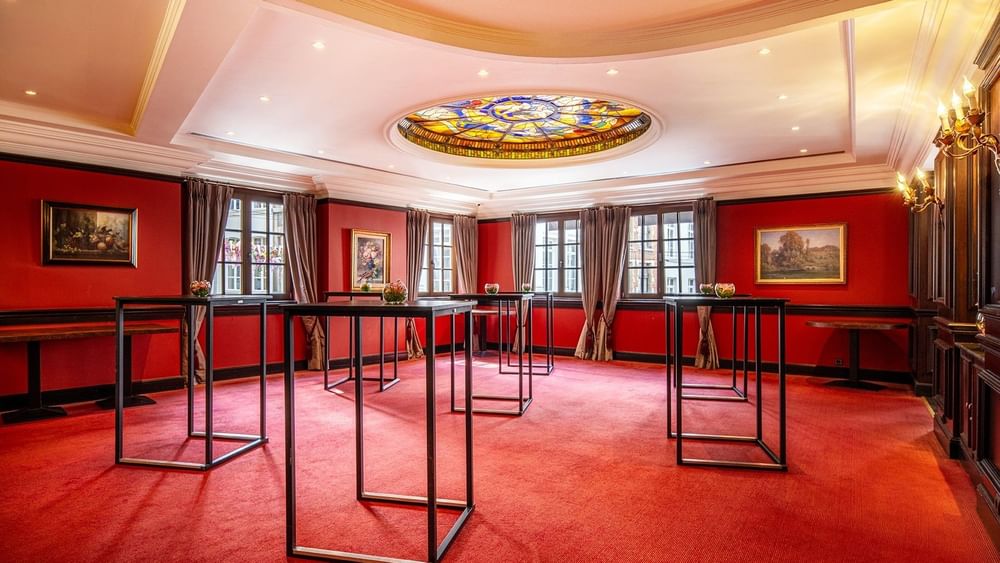 L'élégante salle de réception « Salon Grand-Place », avec tapis rouge et tables en verre, au Warwick Grand-Place Brussels.