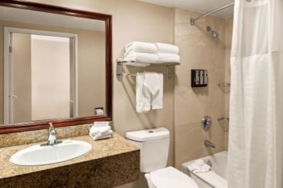 Bathroom bathtub by the vanity in a Room at Anaheim Portofino Inn & Suites