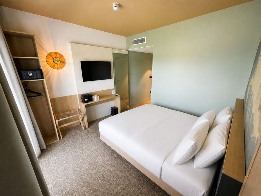 Chambre supérieure propre et moderne avec lit blanc au Osmo Hôtel Chantepie.