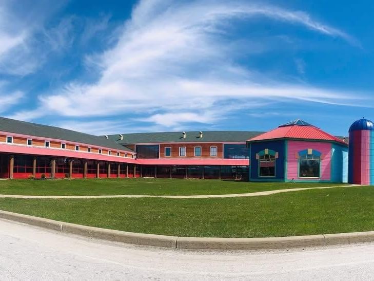 Colorful Vermont Teddy Bear factory building with pink and blue domed structures and green lawn under blue sky