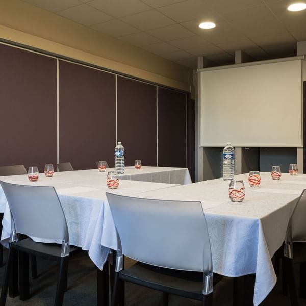 Binic Meeting room with a projector screen at Originals Hotels