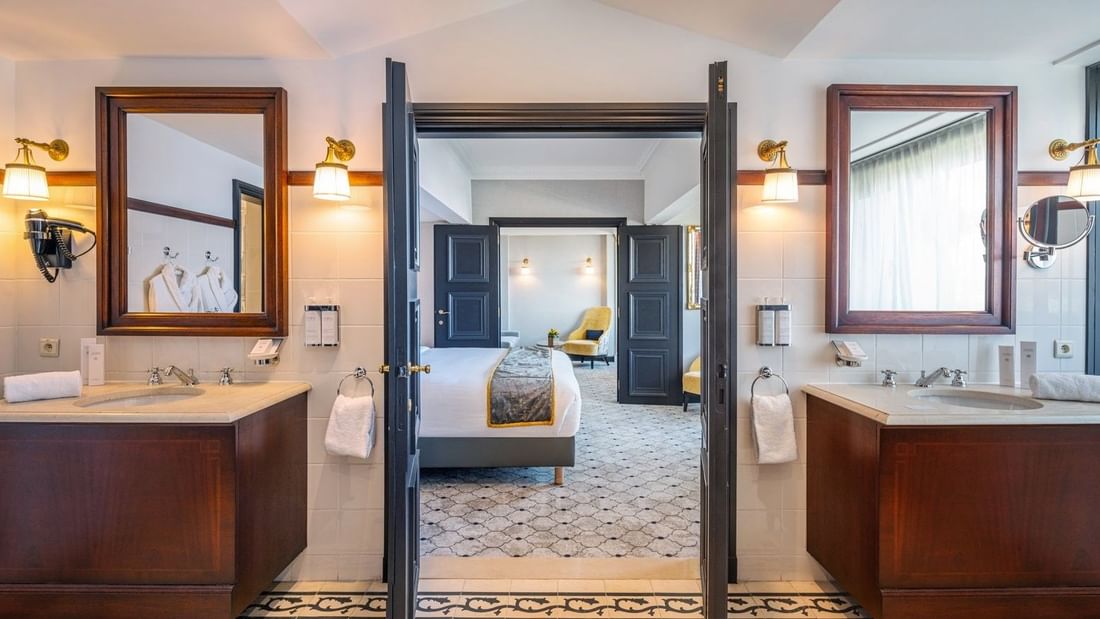 Elegante Barsey Suite-badkamer met dubbele wastafels en open deuren in Hotel Barsey by Warwick.