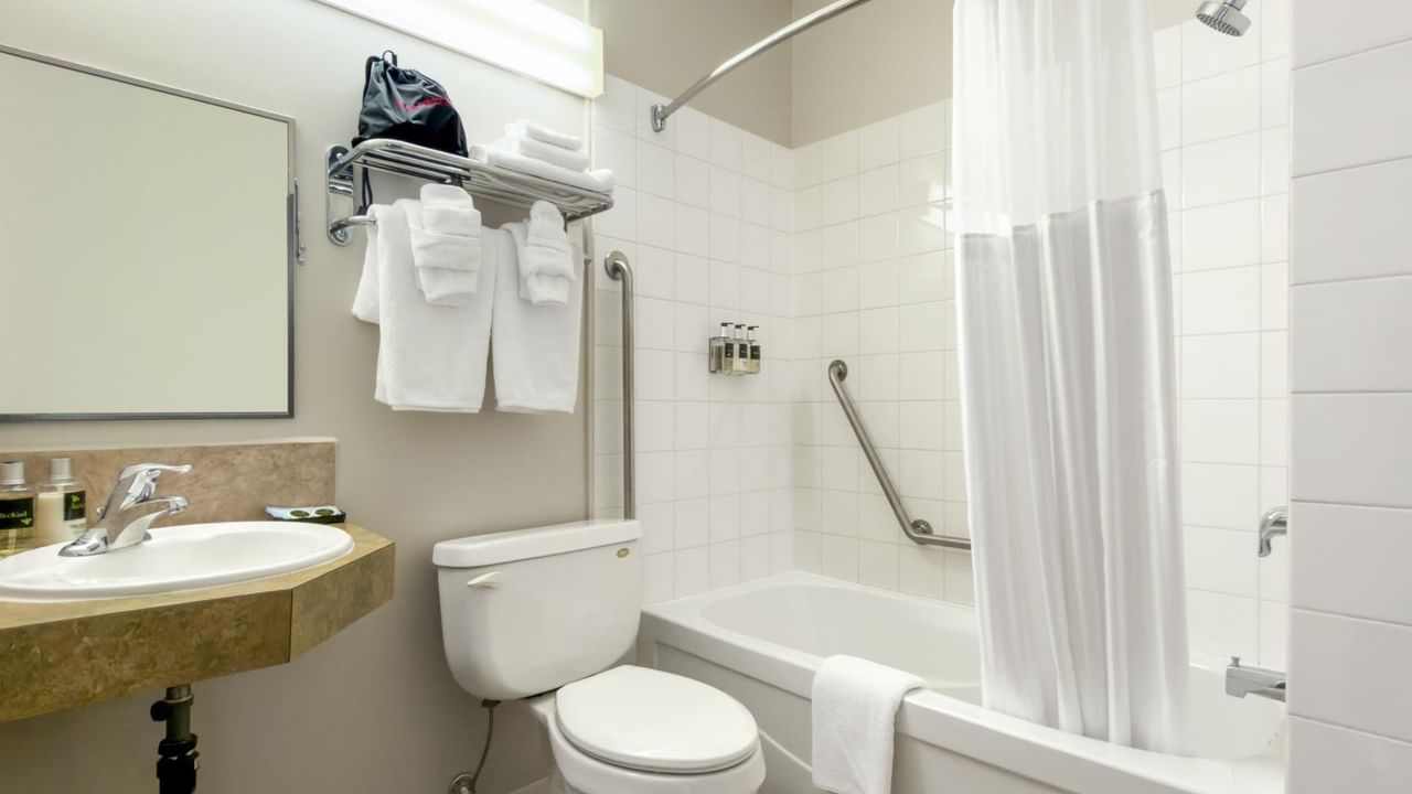 Guest bathroom at Coast Innisfail Hotel with bathtub and shower