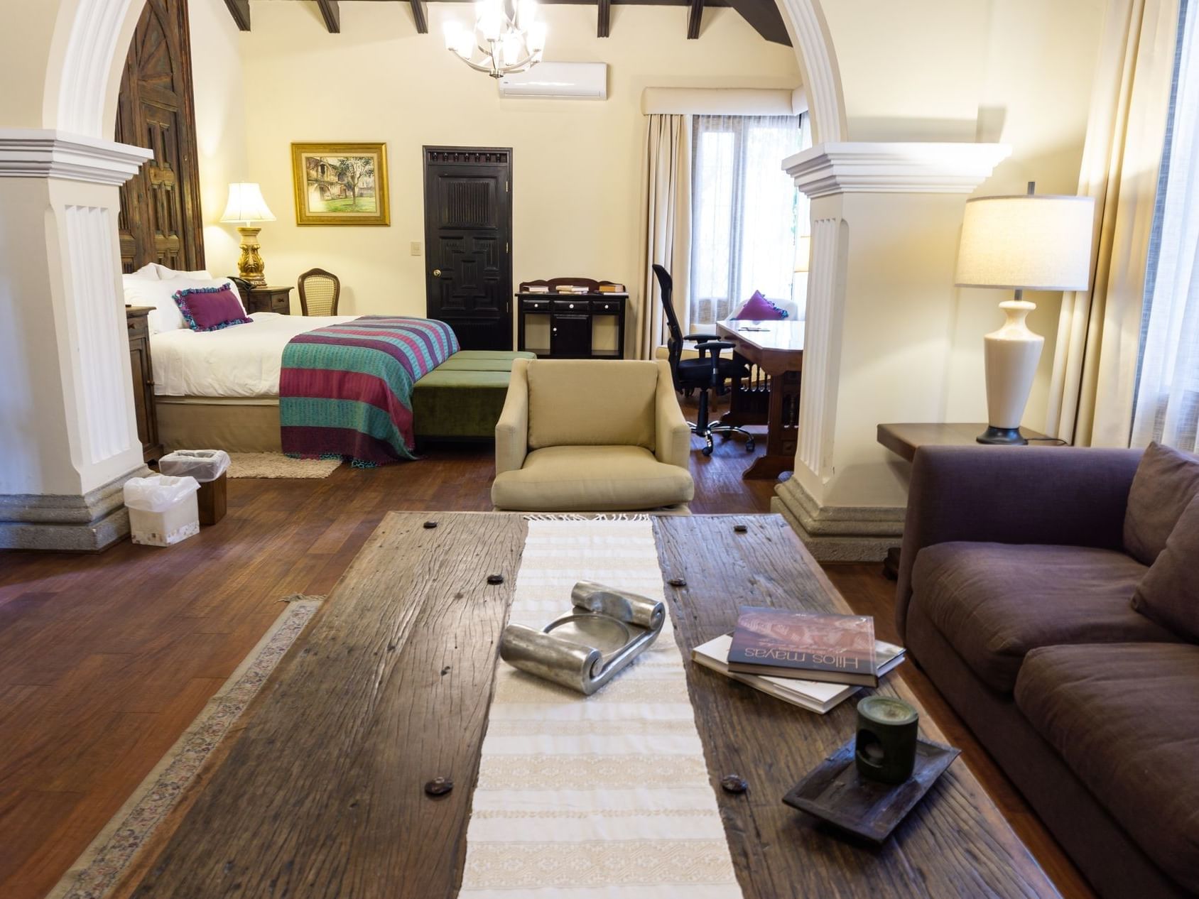 Bedroom & living area in Royal Suite with wooden floors at Pensativo House Hotel