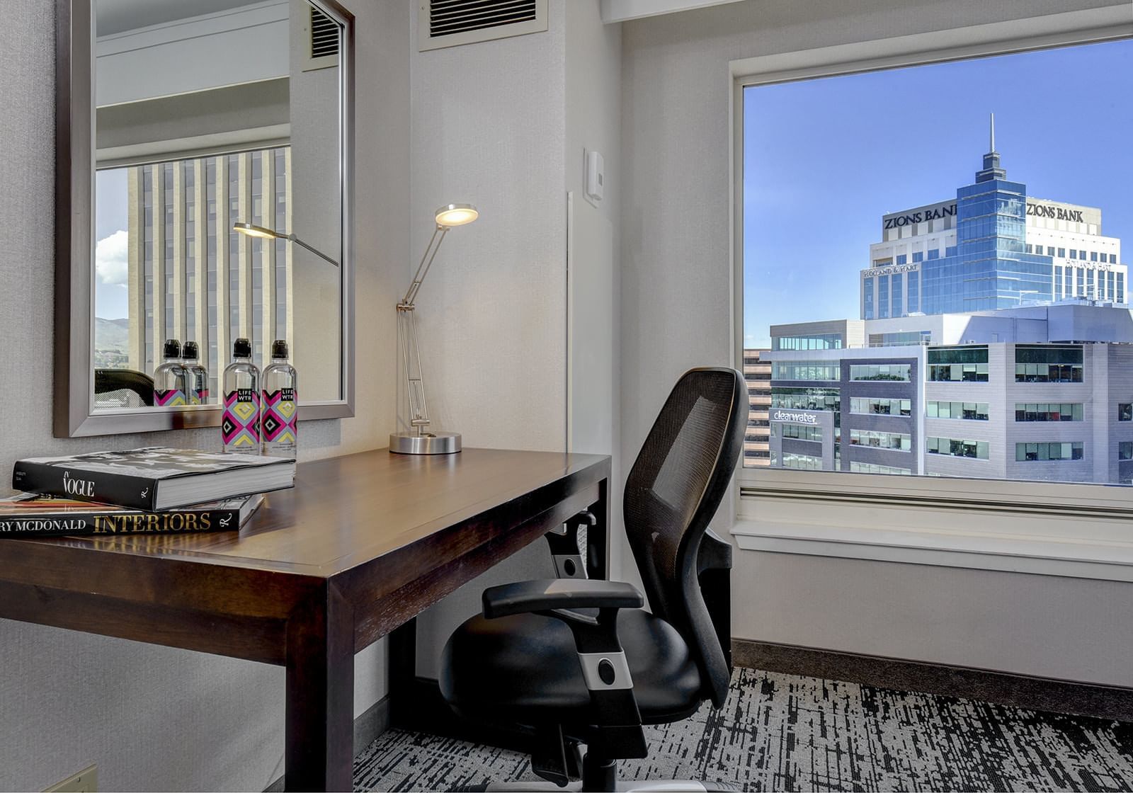 A chair & a desk in a room with the city view at Grove Hotel