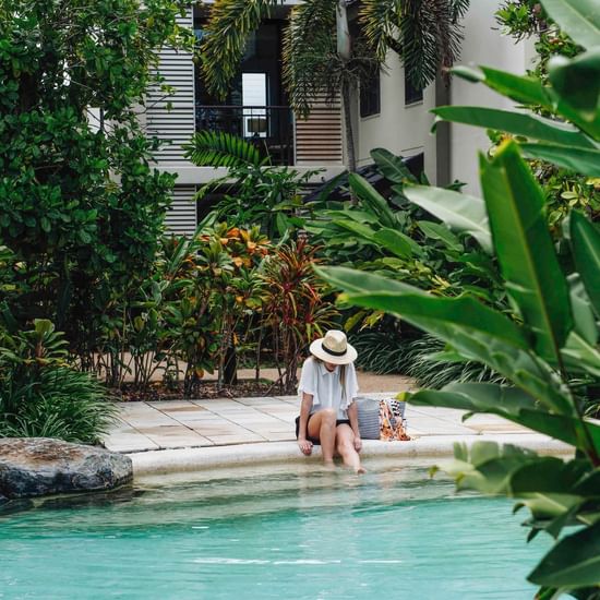 Girl sitting by the lagoon pool at Pullman Port Douglas Sea Temple Resort  Spa