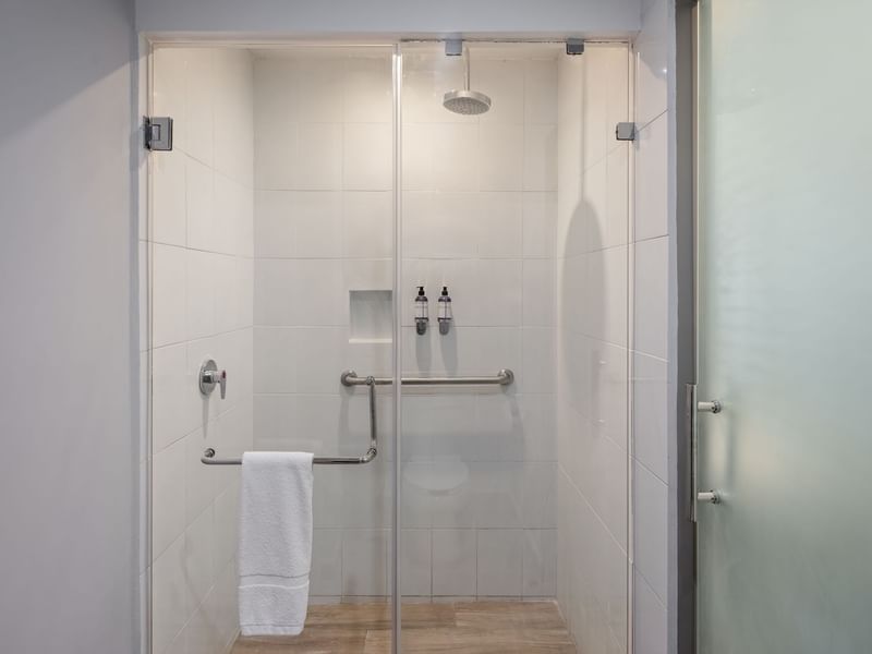 Modern bathroom shower area with a glass door in Junior Suite King at Gamma Hotels