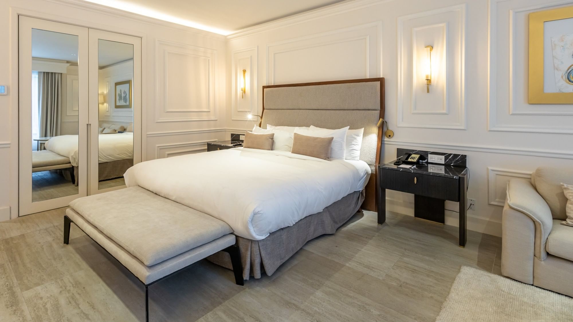 Elegant Suite Gran Clase Premium King with white bedding, mirrored closet doors, and classic molding at Quinta Real Monterrey