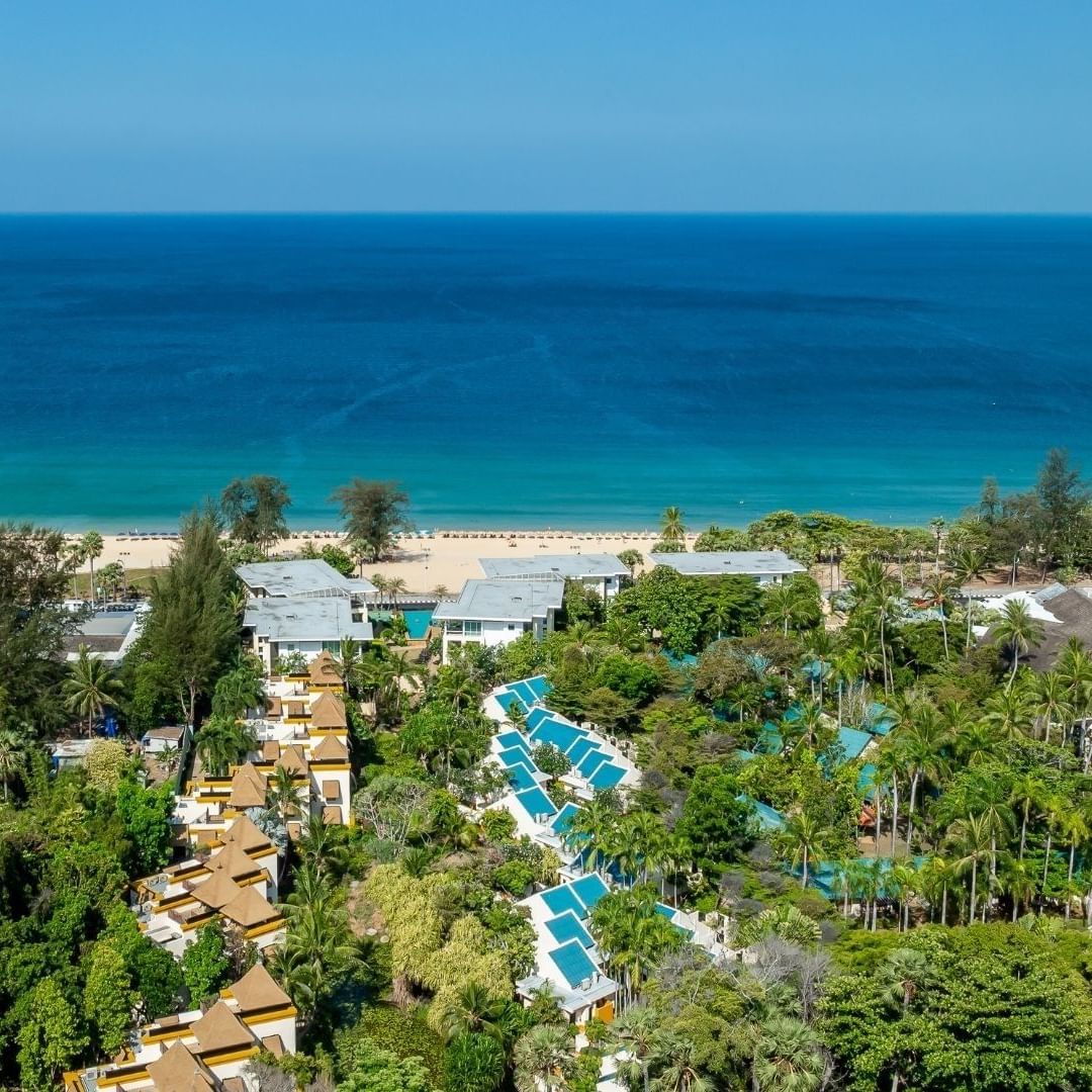 Aerial view of a resort with pools and beach in background for Phuket Weather Guide.