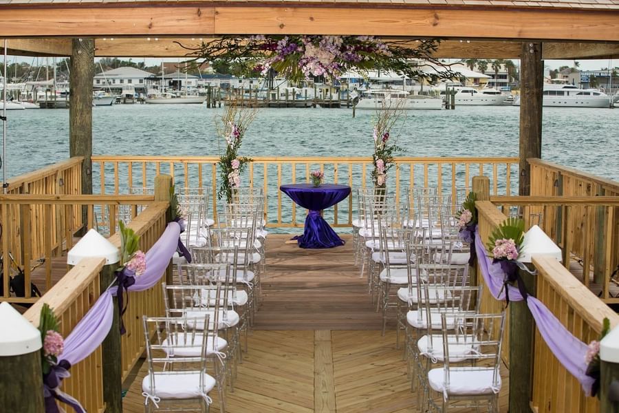 Crystal chairs by a purple table under a floral canopy overlooking the water at Warwick Paradise Island Bahamas