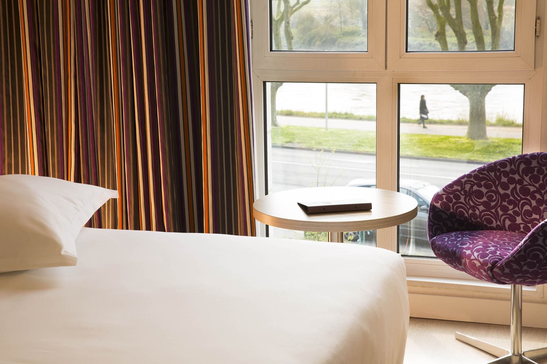 Lit king-size et salon dans une chambre à l'Escale Oceania Orléans