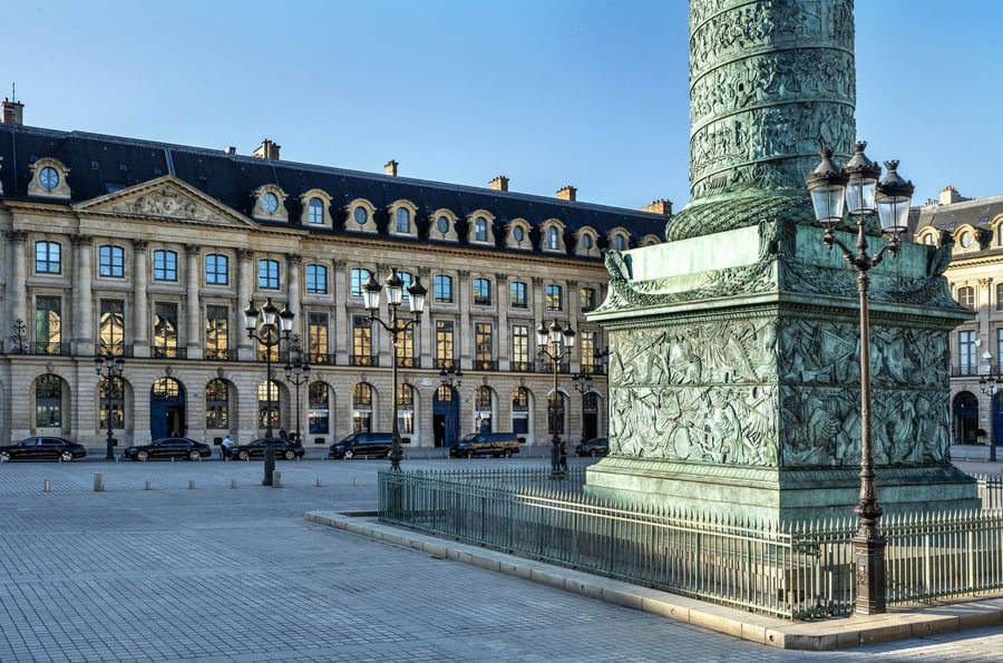 The historic square with a tall bronze column monument and ornate stone buildings near Warwick Hotels & Resorts