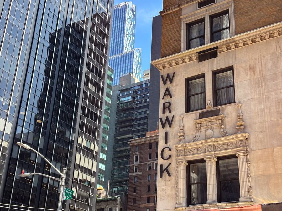 Warwick New York hotel building with city skyline in the background.