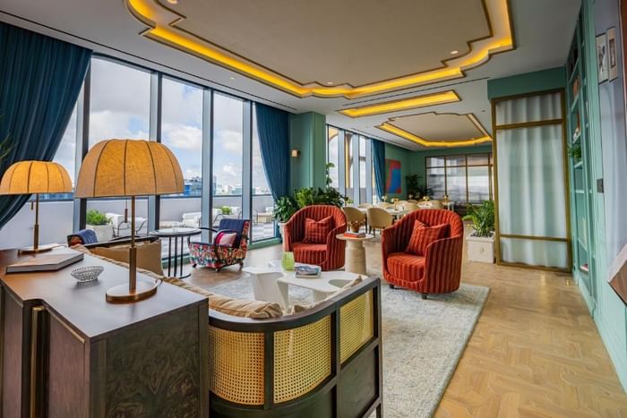 Elegant lounge area with modern decor, large windows, and vibrant seating at The 27 Wynwood