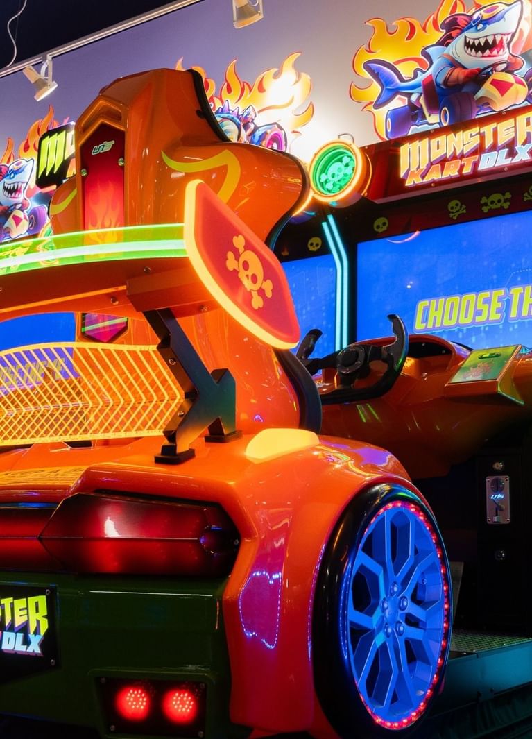Close-up of an orange Monster Kart DLX racer with a skull emblem, under flame graphics at Hotel X Toronto