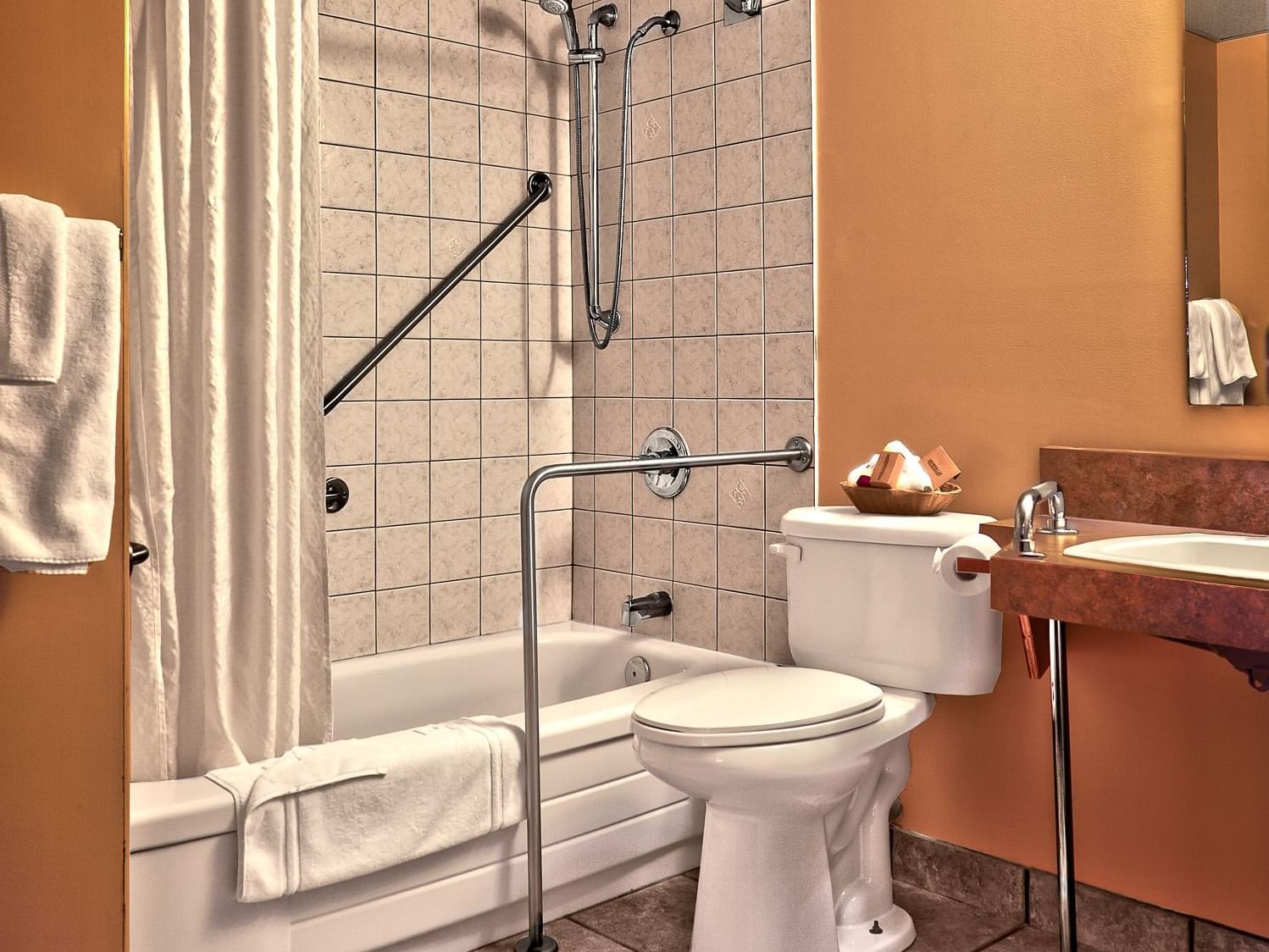 accessible bathroom with tub, handles and vanity