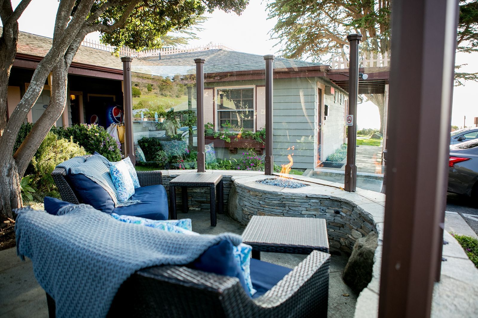 An outdoor seating area with wicker furniture and a fire pit