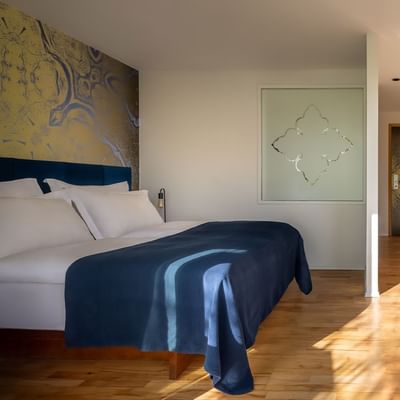 Spavaća soba s krevetom, dva stolca, stolom, ormarom i ukrasnim elementima.