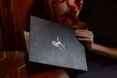 A person holds a menu from The Walnut Restaurant & Bar at the Royal on the Park Hotel