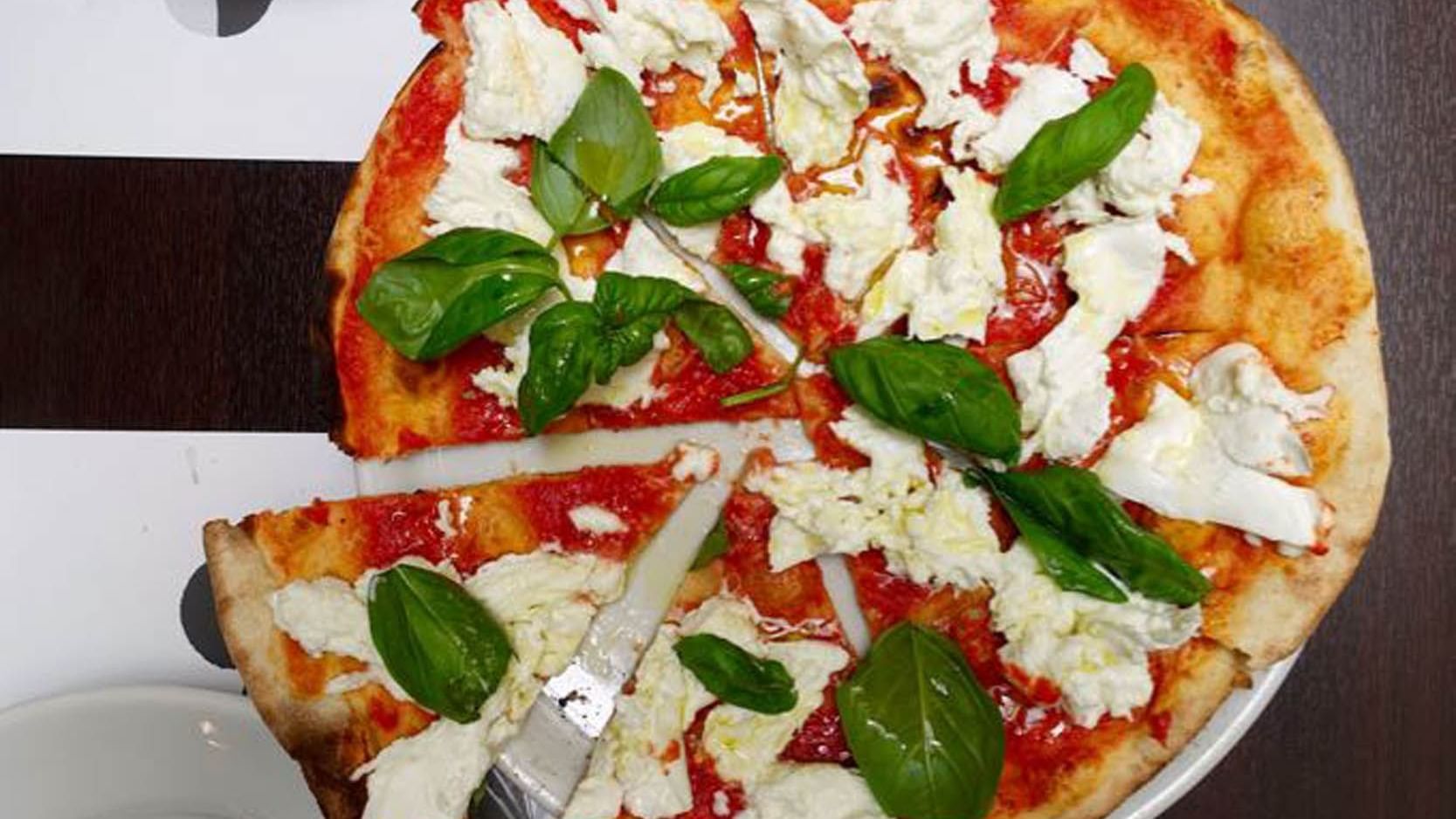 Close-up of a pizza served on a table in Emma restaurant near Rome Luxury Suites