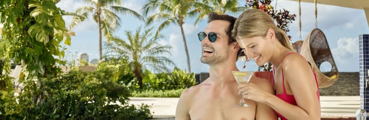 Couple lounging & having cocktails in the pool at La Colección