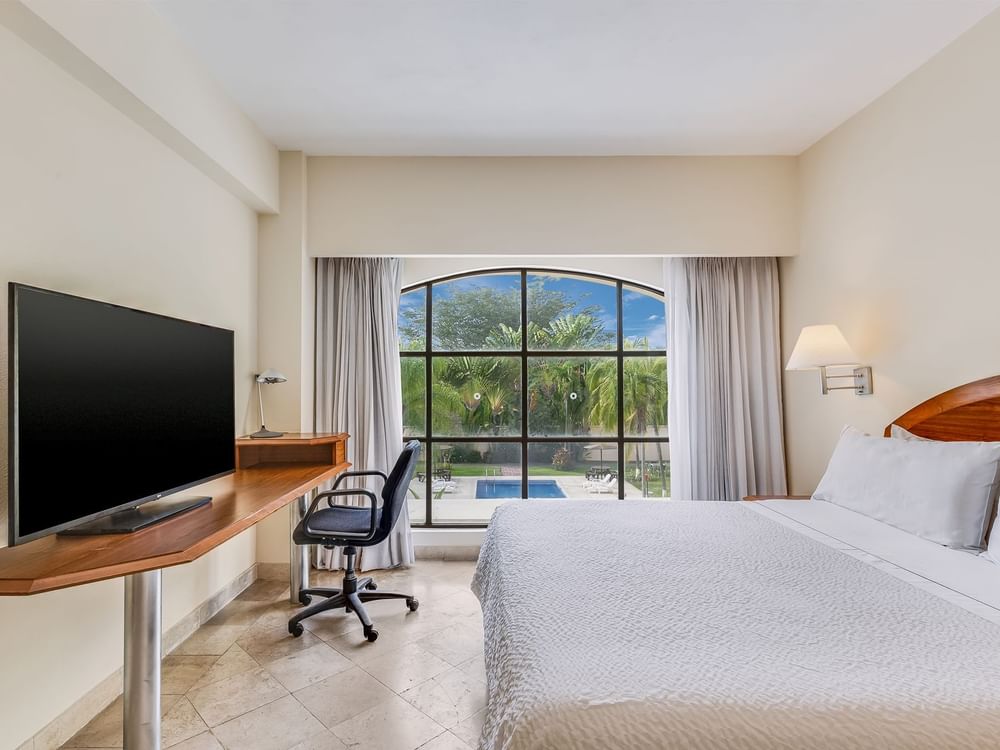 TV & work desk facing king bed with outside view in Superior Room, King at Fiesta Inn
