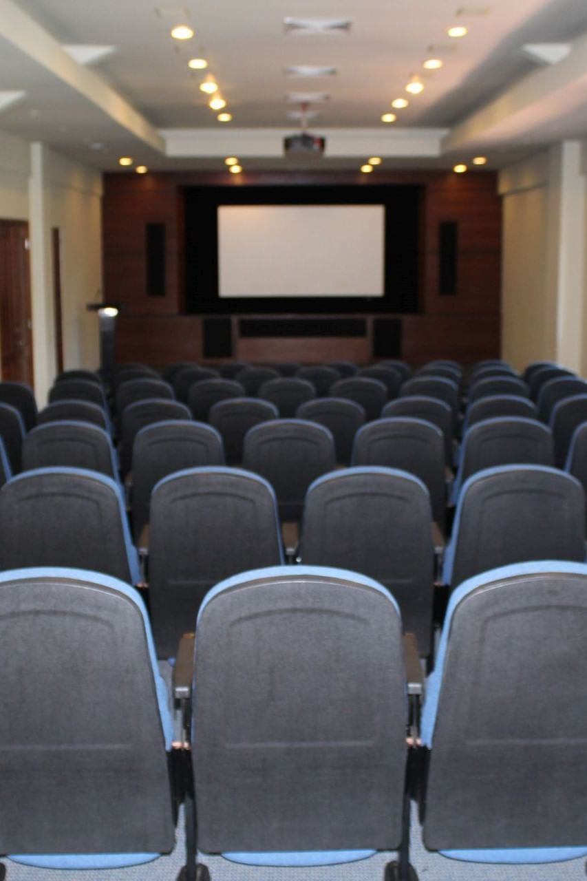 Chair set-up in a auditorium with a screen at Club Hemingway