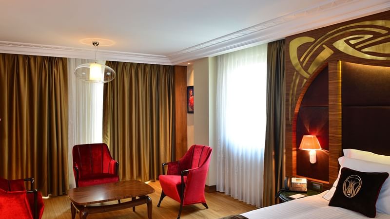 Living area with red comfy chairs in Junior Suite at Warwick Ankara