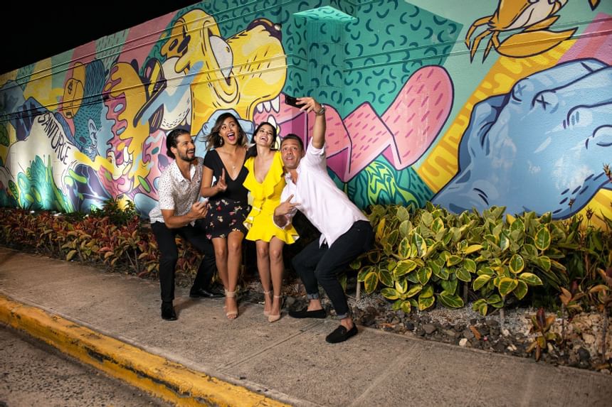 group taking selfie near graffiti art