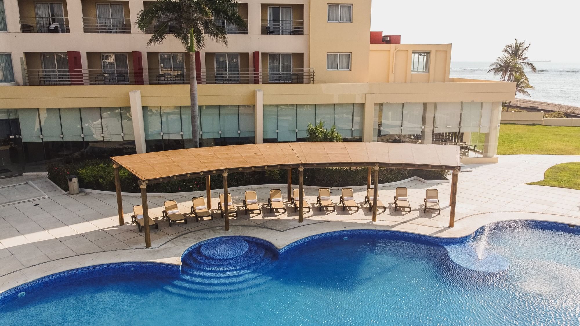 Vista aérea de piscina con cabañas y edificio en Camino Real Veracruz