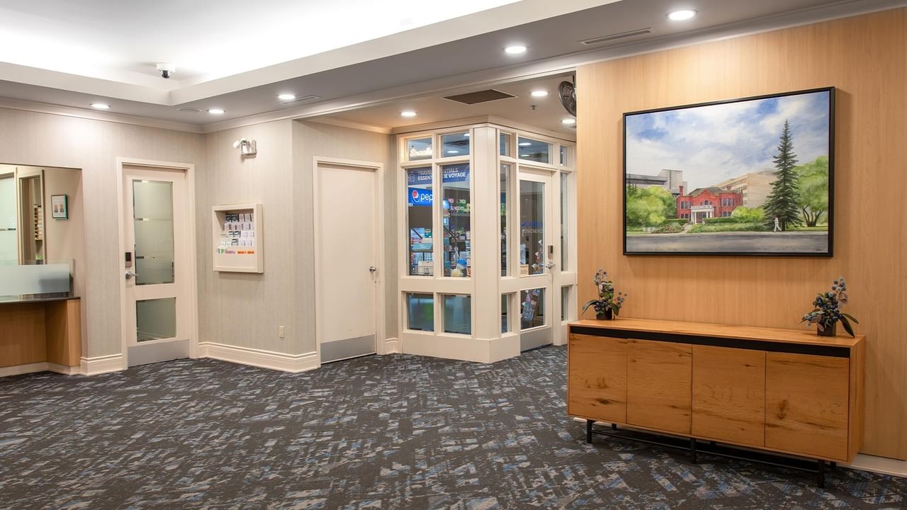 Hotel lobby with seating, wall artwork and a wooden console table.