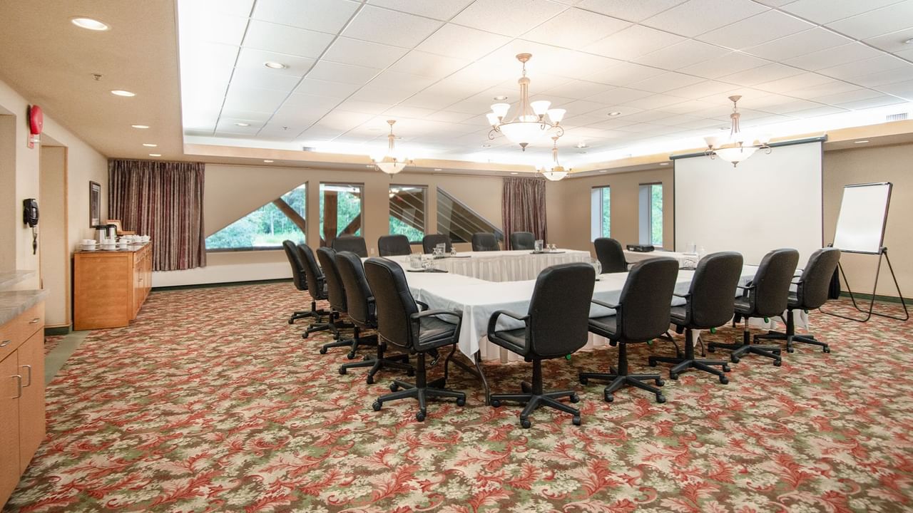 Meeting room with tables, chairs, and projector