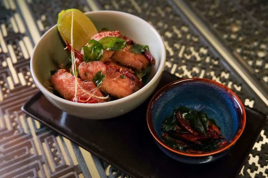 Bowl of crispy fried shrimp garnished with lime, herbs, and dried chilies served in 2 Lams Son at Park Hyatt Saigon