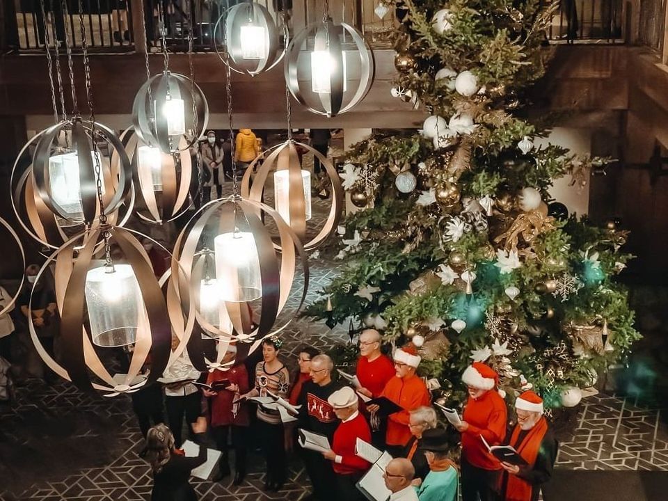 Indoor winter gathering with a speaker and guests near the stone fireplace at Spring Creek Resorts, featuring Canmore events
