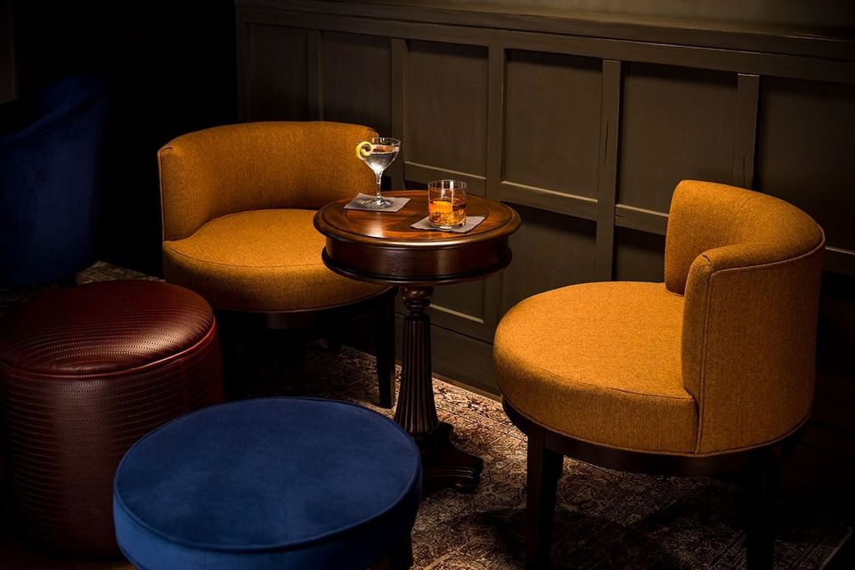Cozy seating area with two mustard armchairs in The Study at the University of Chicago