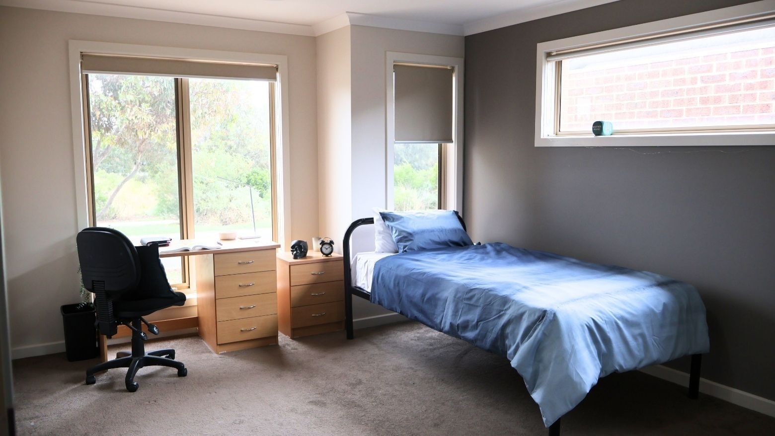 Bedroom with a single bed, desk, chair, and two windows at La Trobe University Regional Housing – Melton.