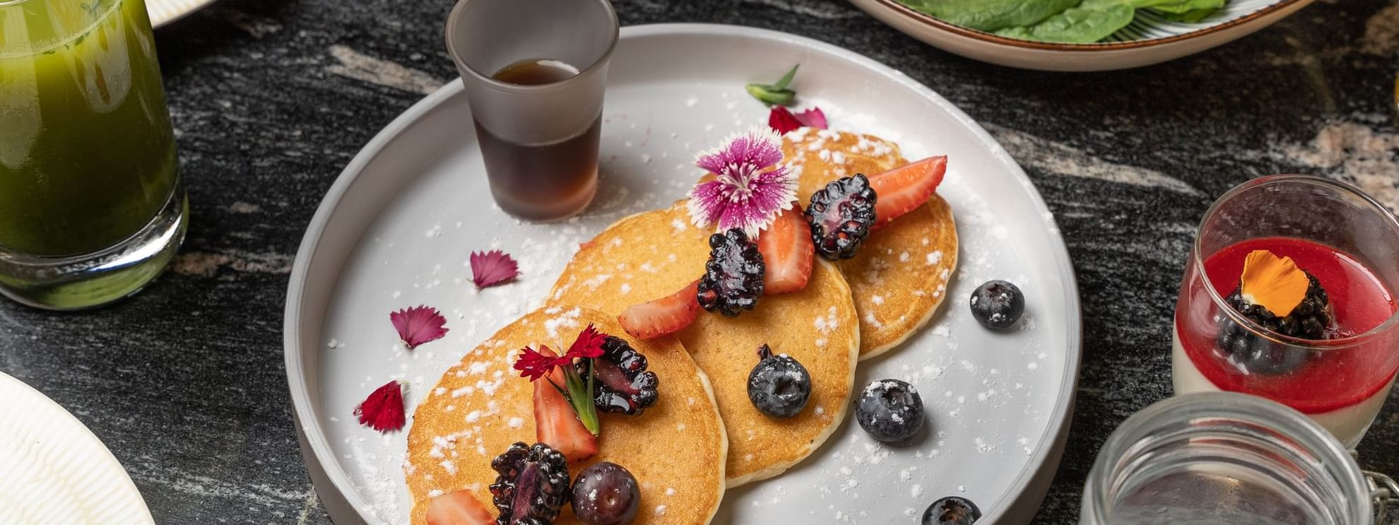 Close-up of breakfast pancakes served with syrup & berries at Azimuth Barcelona