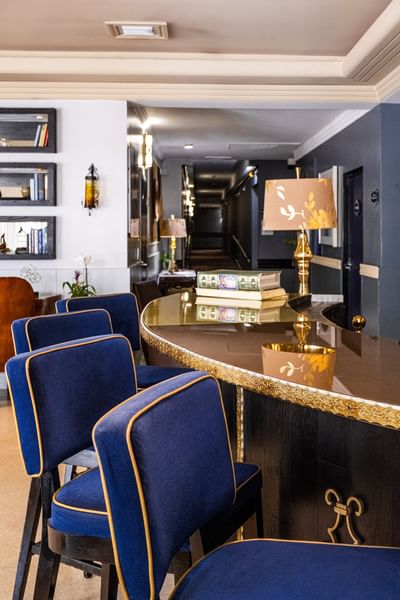 Sophisticated indoor bar at Riviera Hotel South Beach with blue velvet stools and a gold-trimmed counter