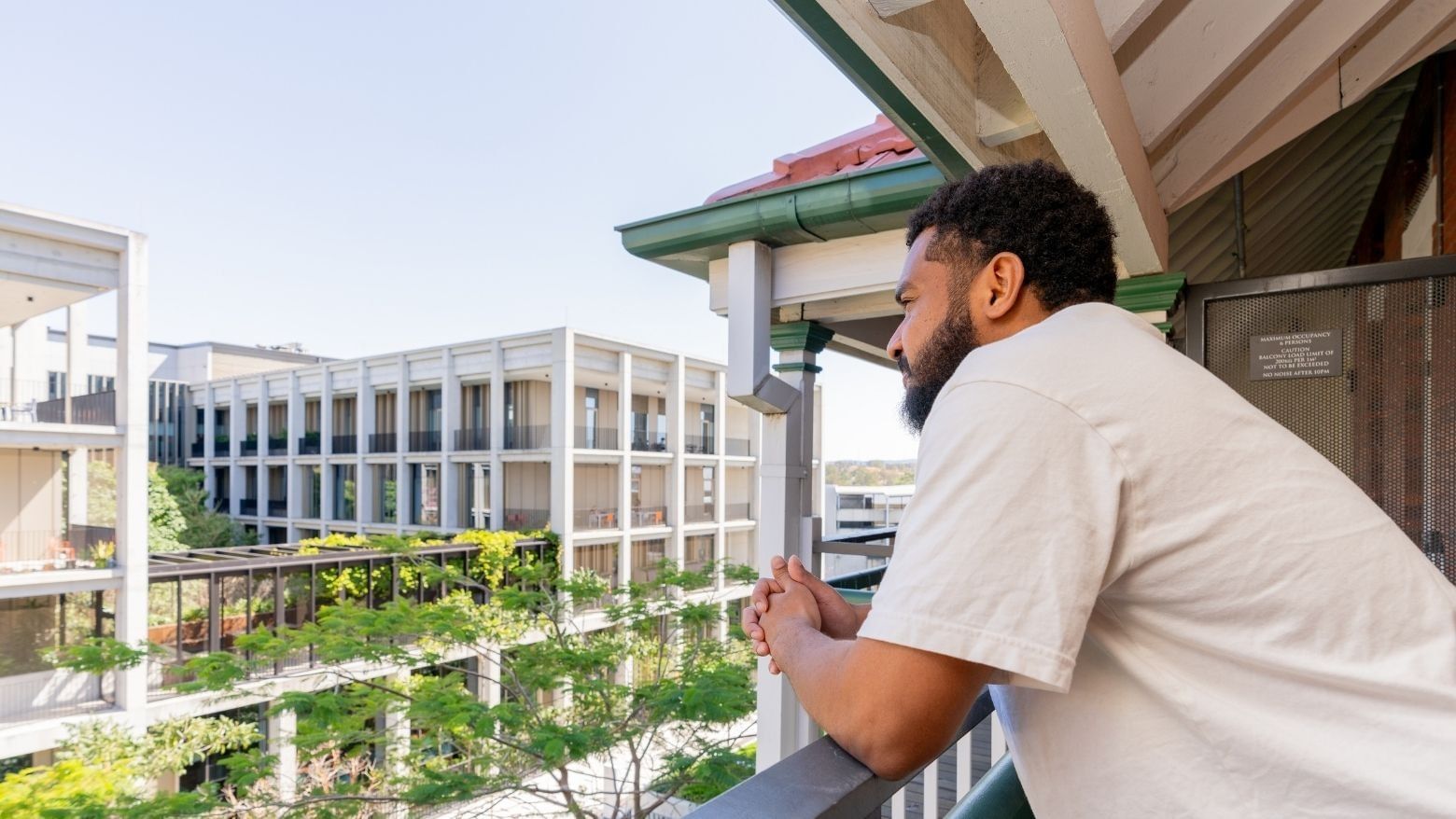 Student looking out from a balcony.