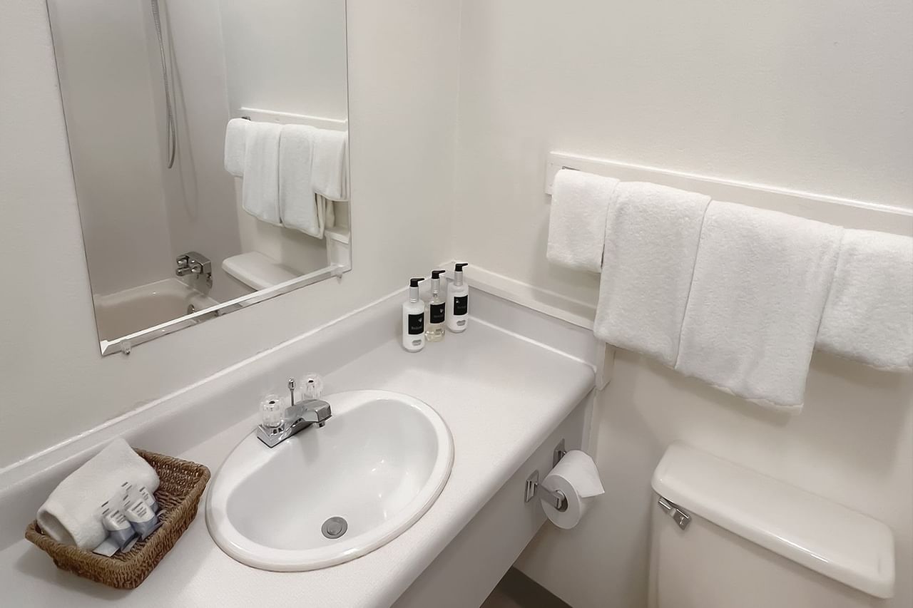 Bathroom with towels, toilet, mirror, sink